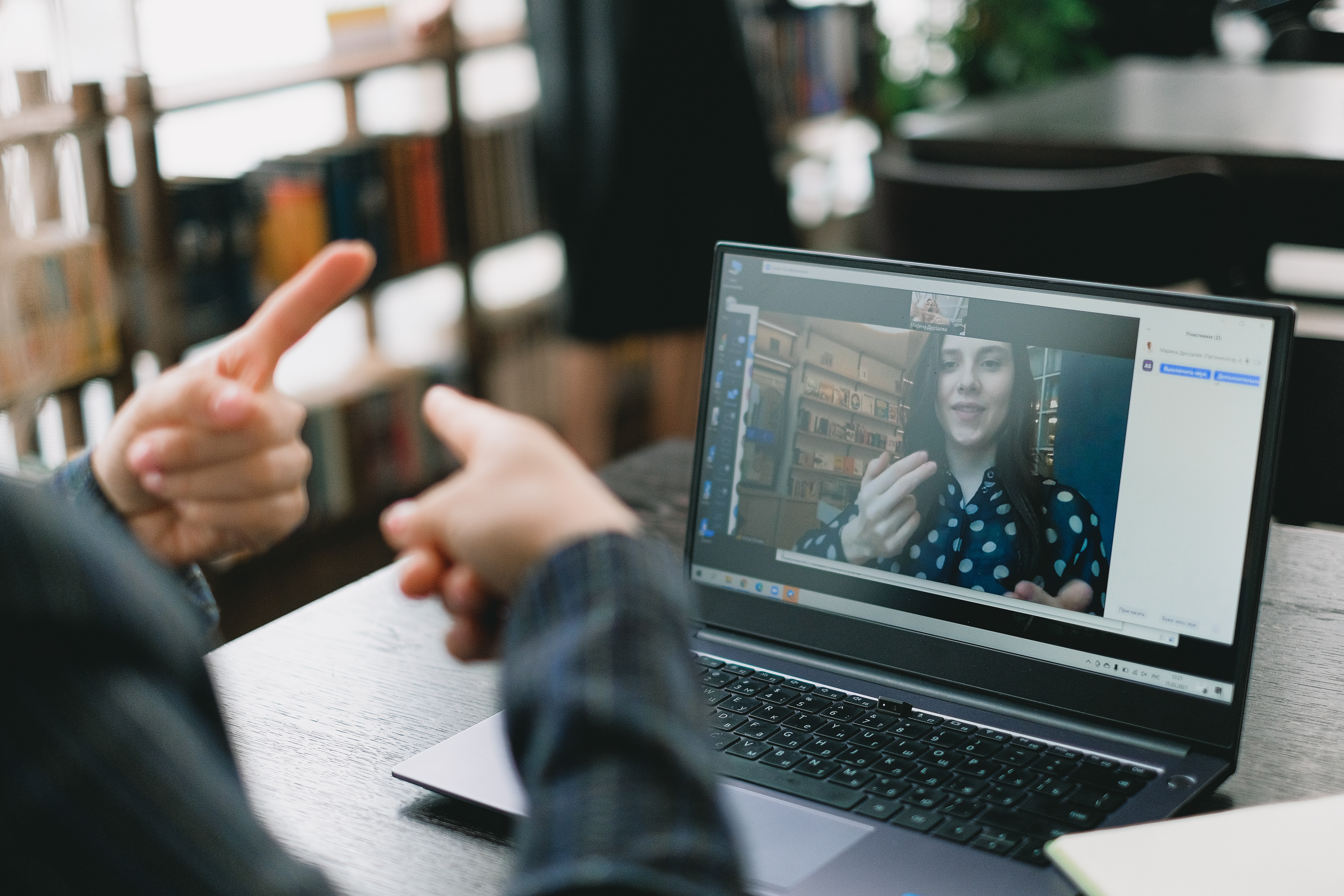 Mulher a aprender língua gestual durante aula online com uma tutora